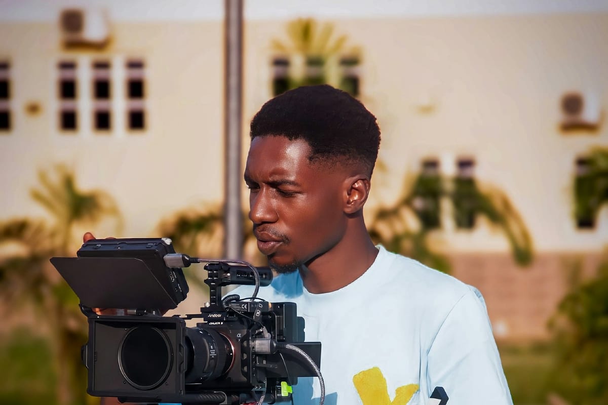 A young man operating a video camera outdoors