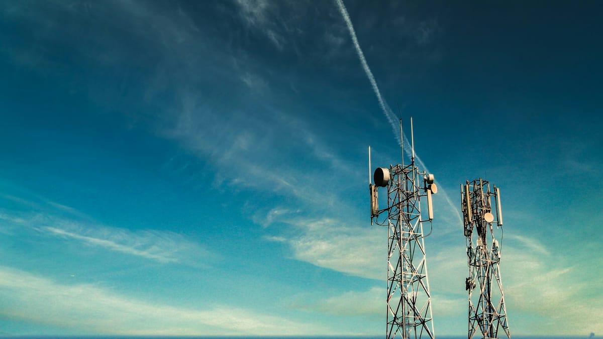Two mobile network masts under a blue sky
