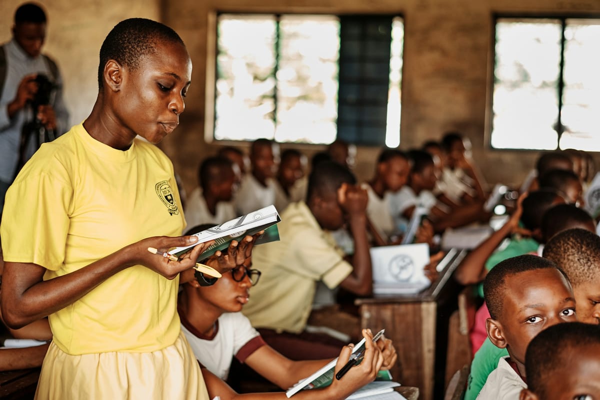 A teacher with a group of pupils in a classroom