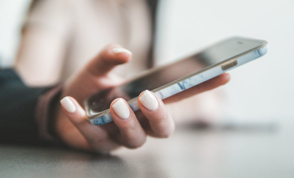 A person holding a smartphone in a bright room