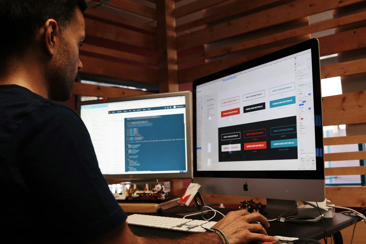 A man designing a website at a desktop computer