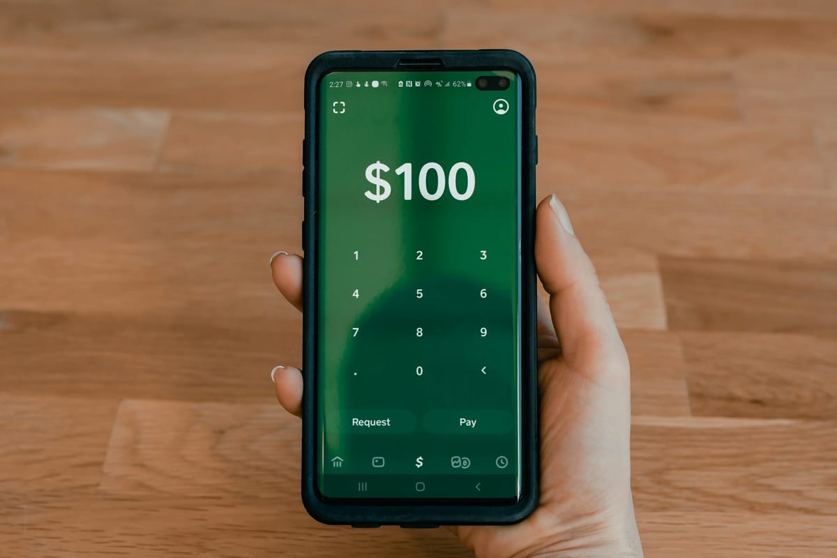 A hand holding a phone with a payment app open