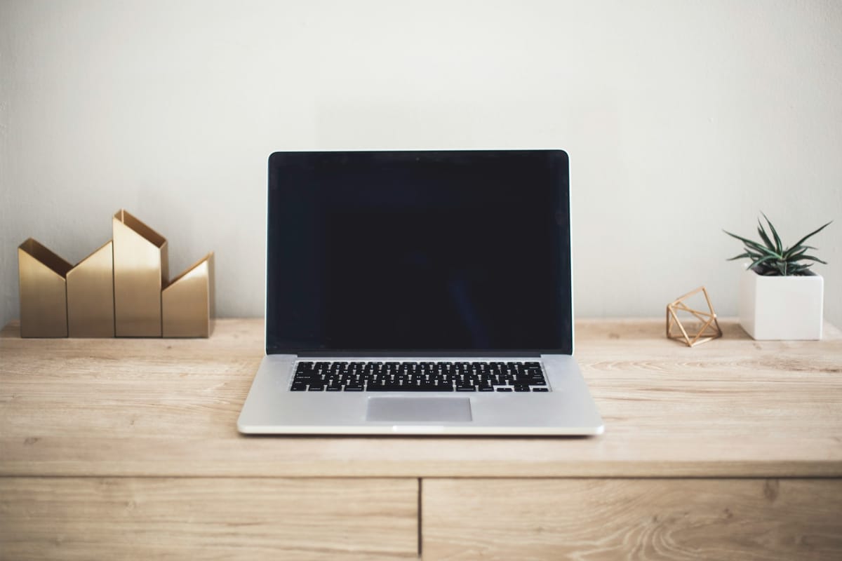 An open laptop on a wooden desk