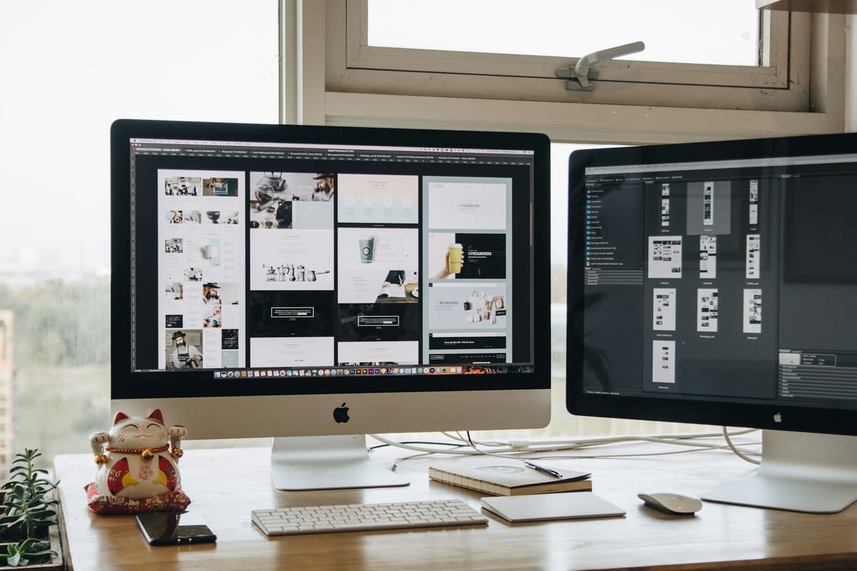 Two large monitors side by side on a desk