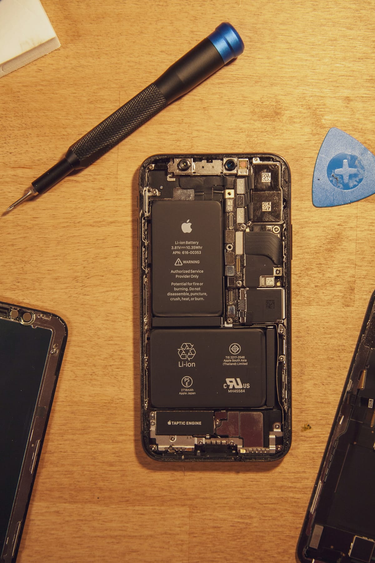 A black smartphone lying on a wooden table
