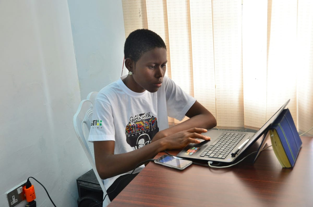A young man designing on a laptop at a desk