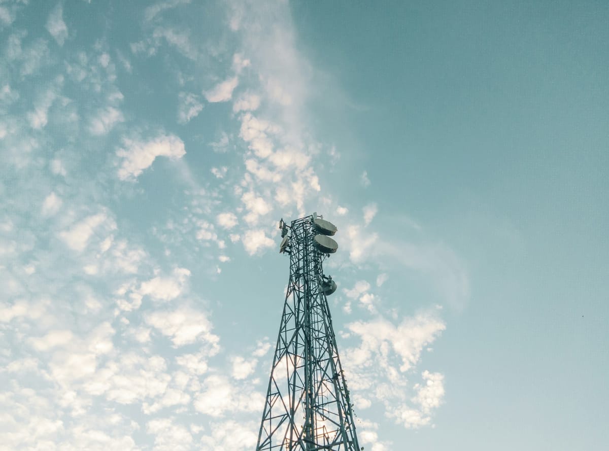 A mobile network mast against a cloudy sky