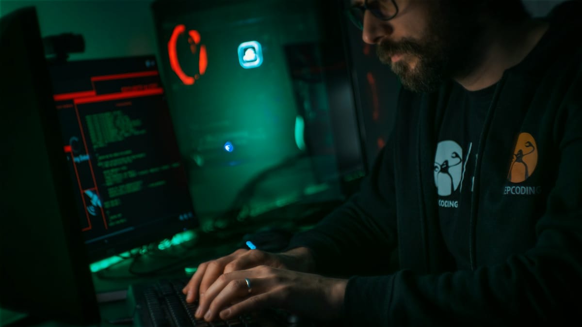 A man typing at a computer showing security warnings