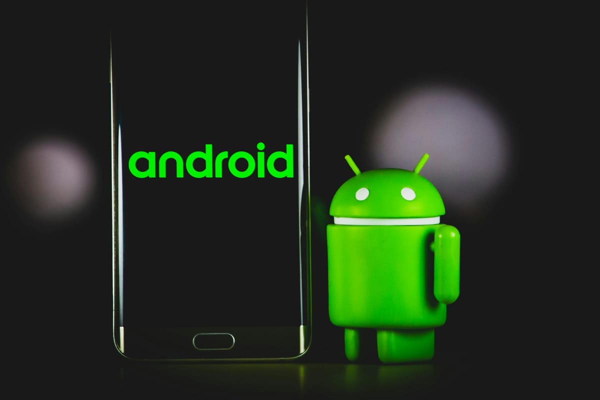 An Android phone beside a green Android figure