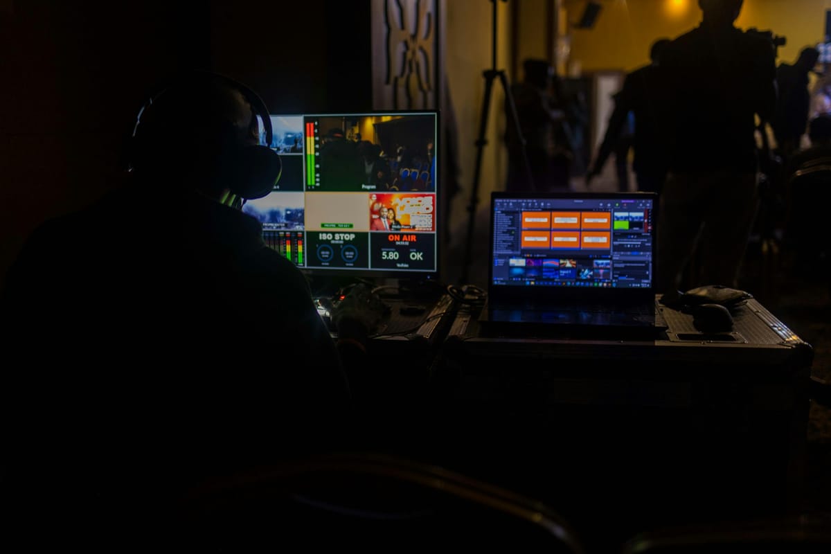 A man working at a laptop in a dark studio