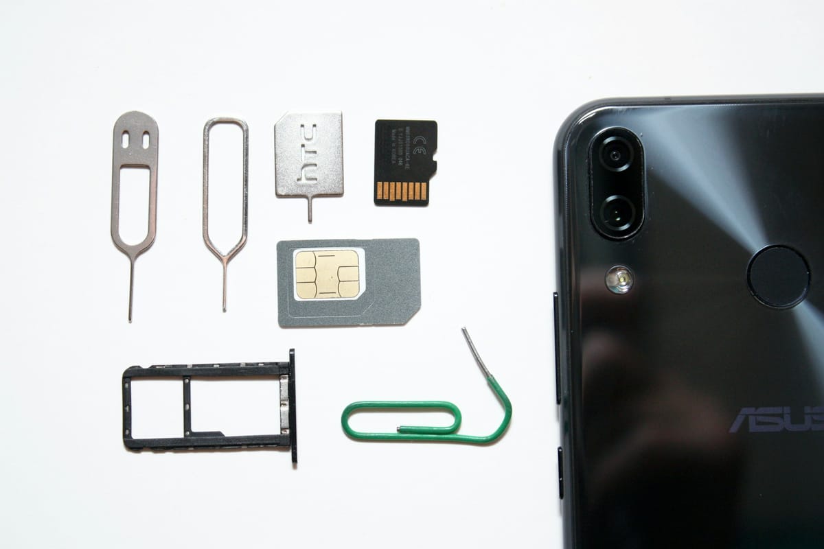 A mobile phone with a SIM card next to it
