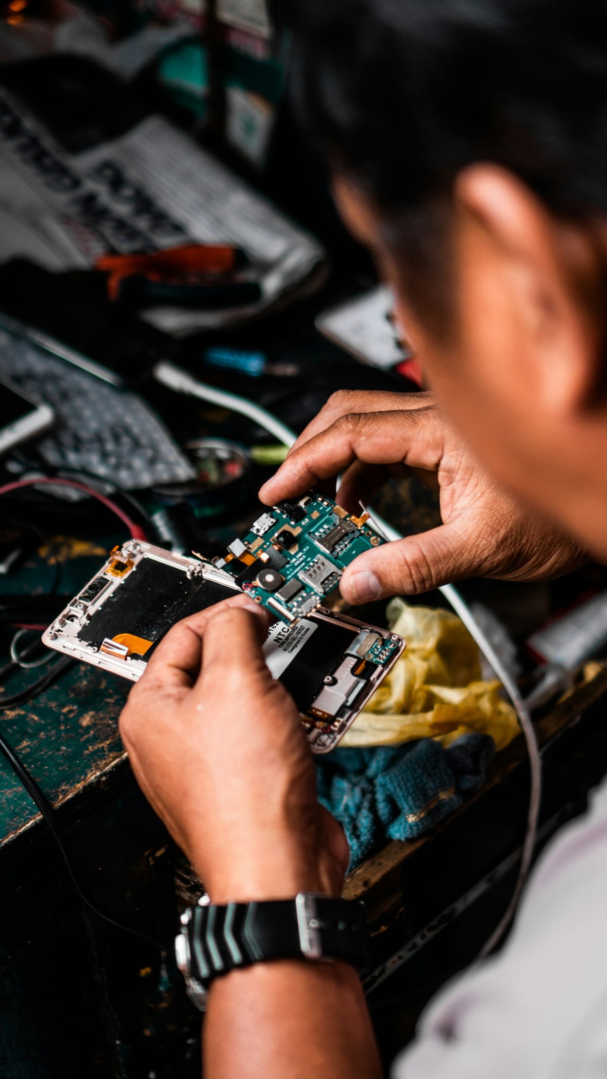 A technician repairing an Android smartphone