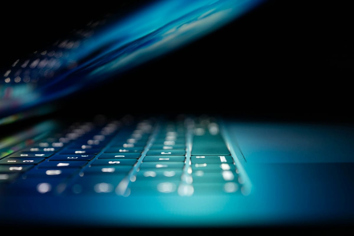 A glowing laptop keyboard in the dark