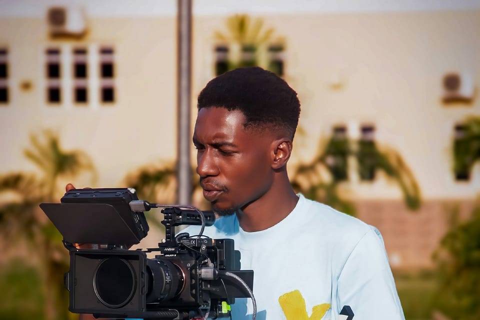 A young man operating a video camera outdoors