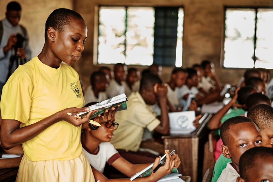 A teacher with a group of pupils in a classroom
