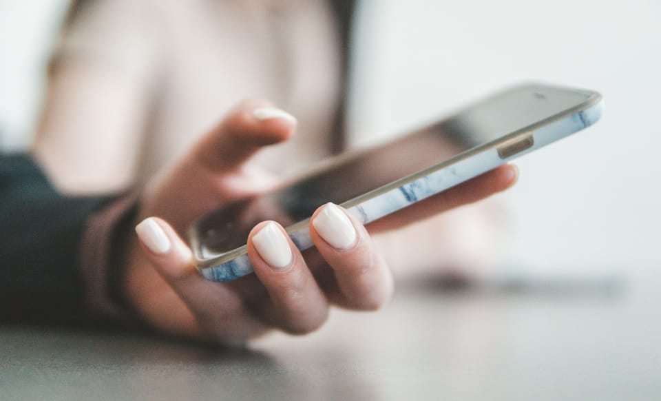 A person holding a smartphone in a bright room