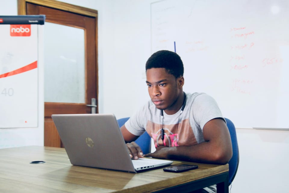A young man working on a laptop in an office
