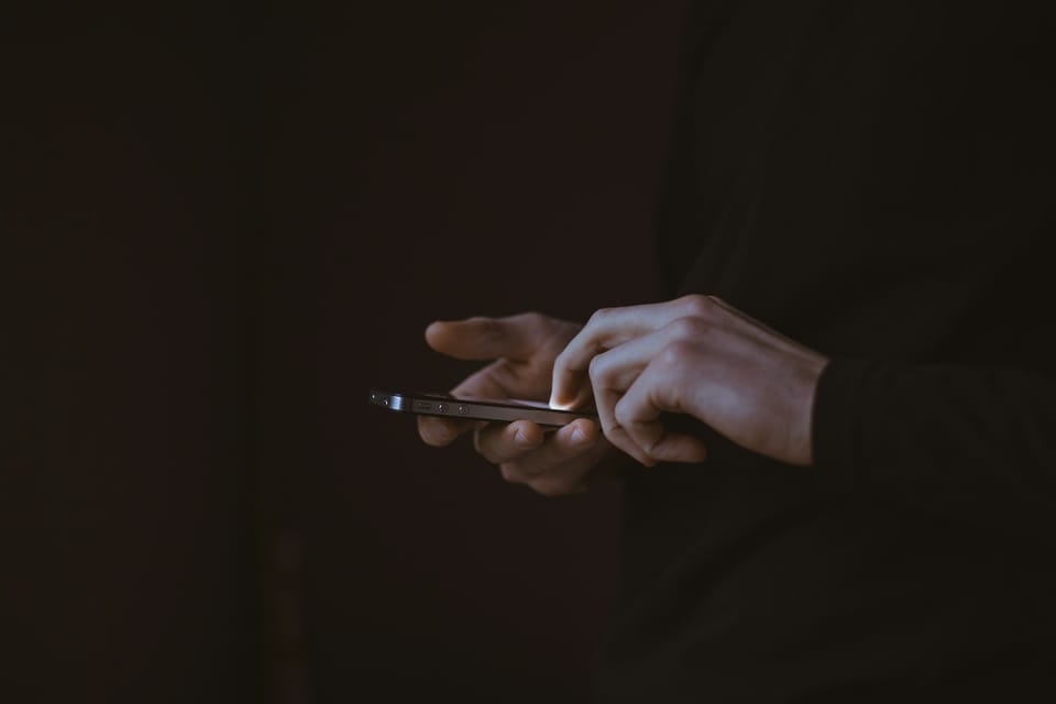 A person holding a smartphone in low light