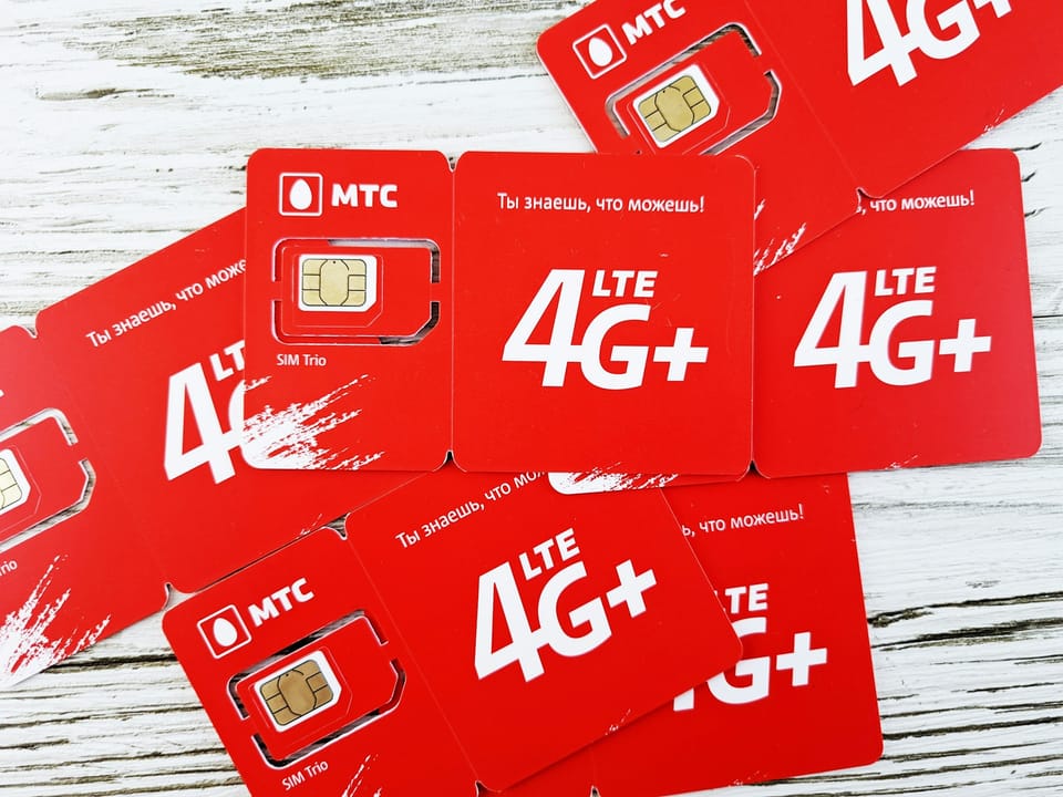 Red SIM cards spread on a wooden table