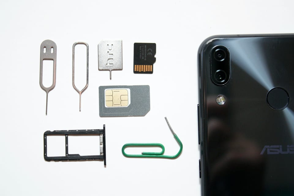 A mobile phone with a SIM card next to it