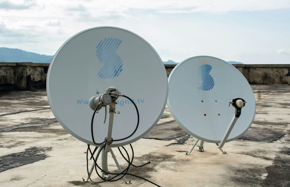 Two satellite dishes on a rooftop